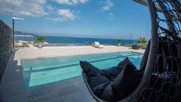 A poolside area with a view of the sea, a hammock, and a lounge chair. - Ozen Suite, Ozen Suite & Villa Crete (Agios Nikolaos Crete)