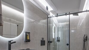 A modern bathroom with a glass shower enclosure, a large mirror, and a built-in sink. - Ozen Suite, Ozen Suite & Villa Crete (Agios Nikolaos Crete)