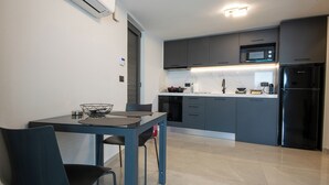 A modern kitchen with grey cabinets, a black refrigerator, and a microwave. - Ozen Suite, Ozen Suite & Villa Crete (Agios Nikolaos Crete)