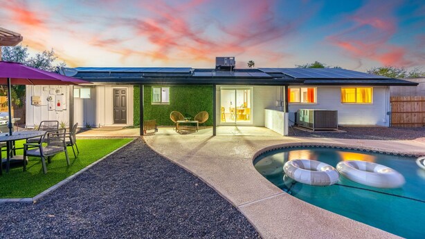 A modern house with a swimming pool, solar panels, and a patio with outdoor furniture. - Sleeps 16 | Heated Pool + Arcade + Backyard Resort (Mesa)