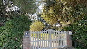 A gated entrance with a brick wall and a white picket fence. - Maison Antoinette (San Vincenzo)