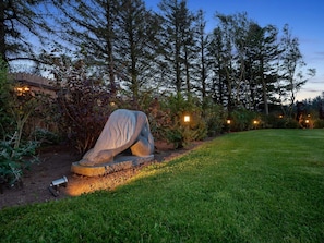 A sculpture in a garden with a wooden fence and trees in the background. - 4 Star Holiday Home in Lokken (Lokken)