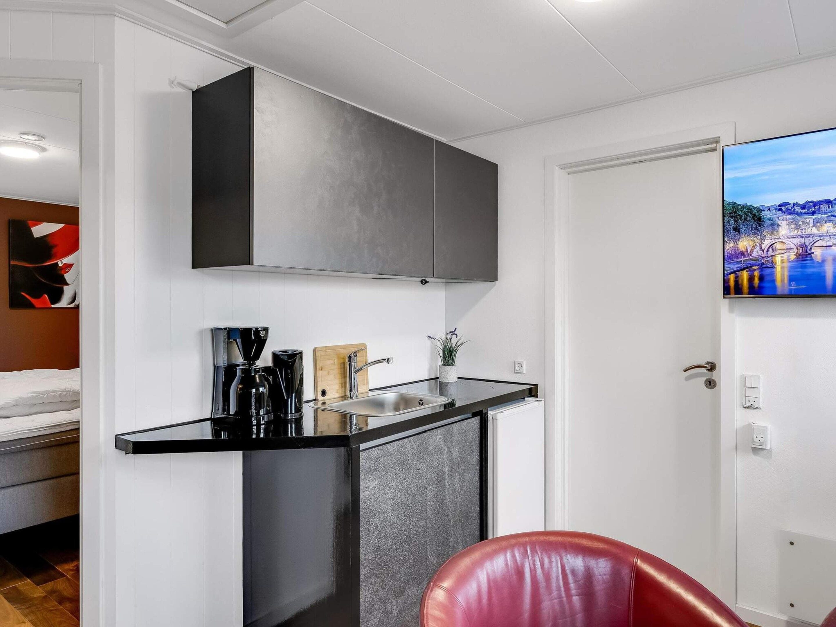A compact kitchenette with a built-in stove, a sink, and a small countertop.