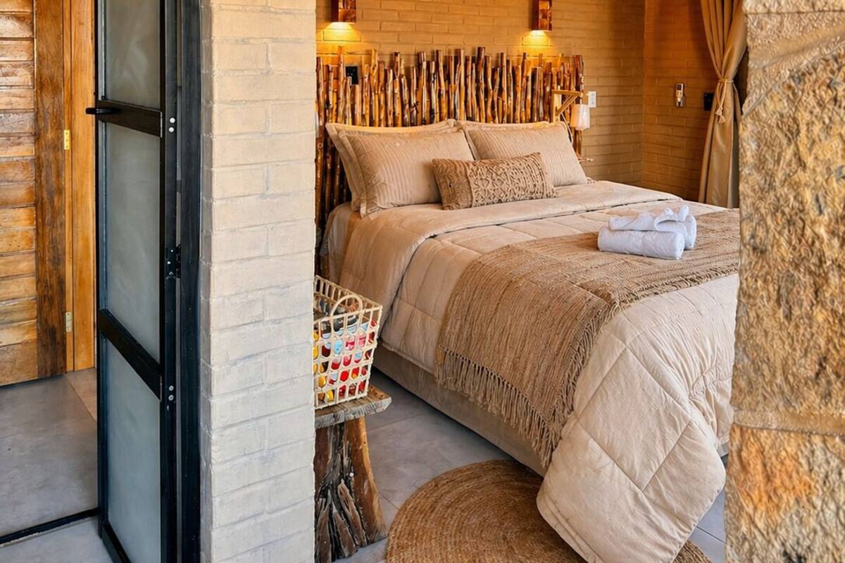 Ein Schlafzimmer mit einem Bett, einem Korb, einem runden Teppich und einer Holzbalkendecke.