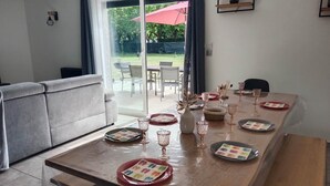 Ein Essbereich mit einem Holztisch, gedeckt für vier Personen, mit klarem Glas und Geschirr mit farbenfrohen Mustern.