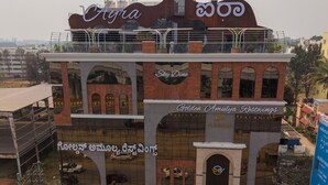 A multi-story building with signage for 'Sky Dine' and 'Golden Amulya Restwings.' - Hotel Golden Amulya Rest Wings (Bengaluru)
