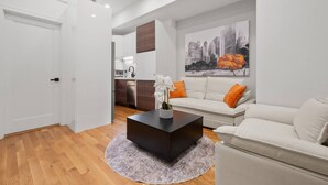 Ein modernes Wohnzimmer mit einem weißen Sofa, einem Couchtisch und einem Stadtbild.