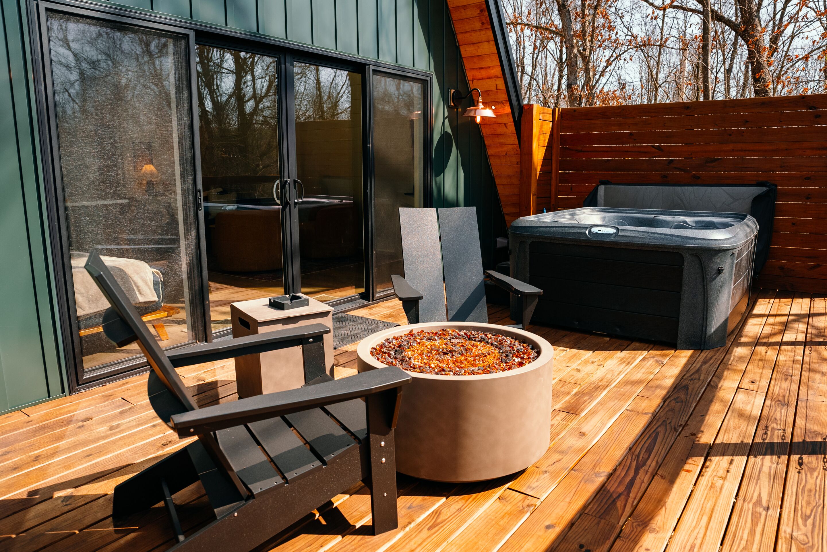 A deck with a hot tub, seating, and a fire pit.