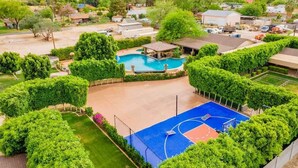 Ein Wohngebiet mit Schwimmbad, Basketballplatz und gepflegter Grünfläche.