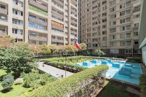 A high-rise residential building with a swimming pool and landscaped garden. - VRS Apartment Santiago Chile (Santiago)