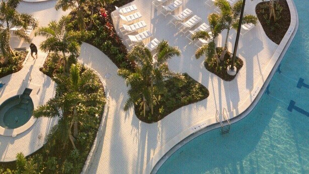 Ein Resort mit mehreren Schwimmbecken, Liegebereichen und Palmen.