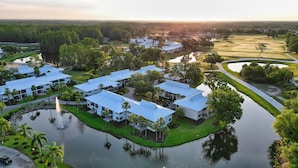 A resort with multiple buildings, a body of water, and a golf course.