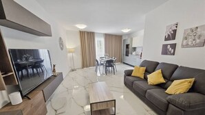 Una sala de estar moderna con un sofá, una mesa de centro y un televisor.