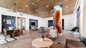 A spacious lobby with a wooden ceiling, a large pillar, a dining area, and a seating area. - Luxury Downtown Austin Condo Near Rainey Street (Austin)