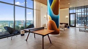 A modern interior with large windows, a wooden ceiling, and a colorful cylindrical column. - Luxury Downtown Austin Condo Near Rainey Street (Austin)