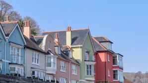Uma fileira de casas coloridas com estilos arquitetônicos distintos, incluindo telhados pontudos e sacadas.