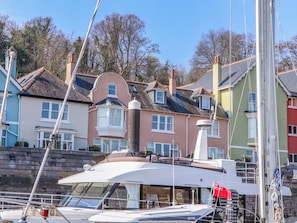 A marina with boats docked, a prominent Raymarine surveillance camera, and colorful houses in the background. - 26 Dart Marina (Dartmouth)