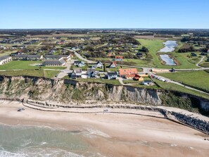 An aerial view of a coastal town with houses, a beach, and a river. - 4 Star Holiday Home in Lokken (Lokken)