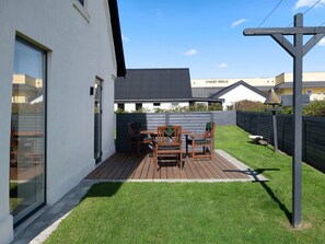 A modern house with a patio, a deck, and a fenced backyard. - 4 Star Holiday Home in Lokken (Lokken)