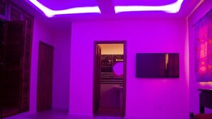 A room with a bed, a television, and a door leading to another room. - RESIDENCE MBESSA (Abidjan)