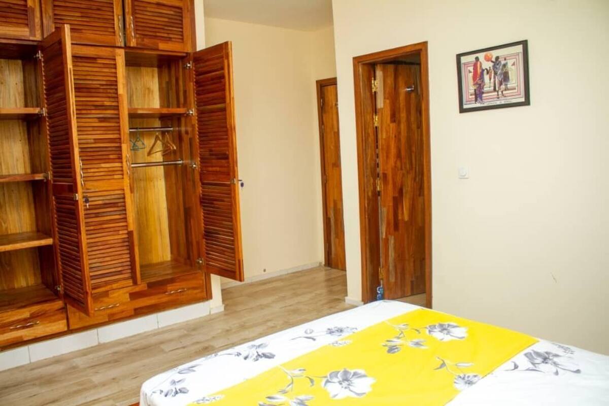 Une pièce avec un lit, une armoire en bois et une porte.