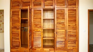 A wooden wardrobe with multiple compartments and a hanging rod. - RESIDENCE MBESSA (Abidjan)