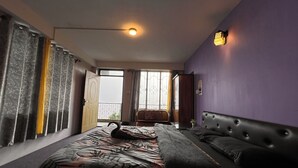 A bedroom with a bed, a sofa, a window with curtains, and a ceiling light.