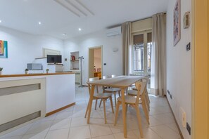 Eine moderne Küche mit Essbereich, Fernseher und großem Fenster.
