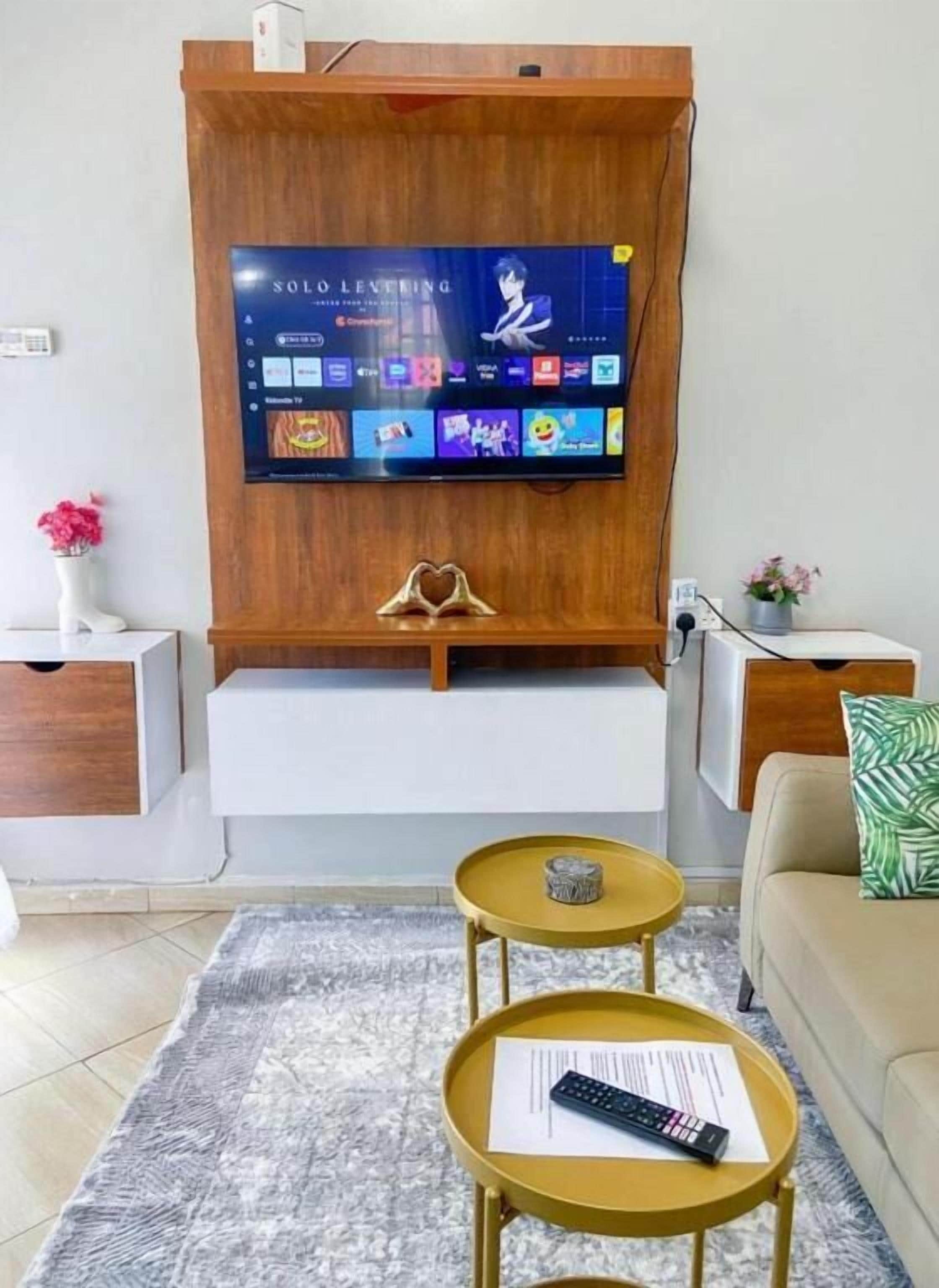 A modern living room with a mounted TV, a sofa, a coffee table, and a small side table.