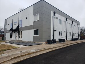 A modern building with a flat roof, large windows, and a concrete ground floor. - Welcome To East Dallas! King Bed! Near It All (Dallas)