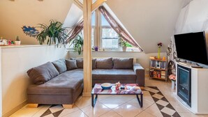 Un salon confortable avec un canapé, une table basse, une cheminée et un téléviseur.