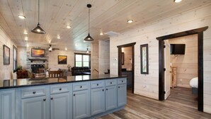 A spacious kitchen with a large island, wooden ceiling, and pendant lighting. - Creekside Paradise: Hot Tub,Arcade Games,NEAR PF! (Pigeon Forge)