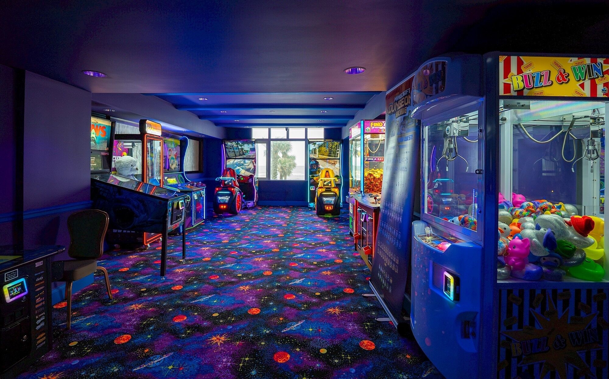A room with arcade games, a car-themed game, and a claw machine.