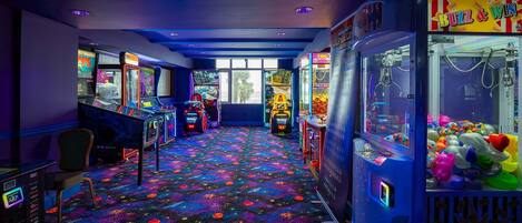 A room with arcade games, a car-themed game, and a claw machine.