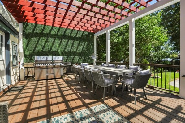 Une terrasse extérieure équipée d’un barbecue, d’une table à manger et de chaises.