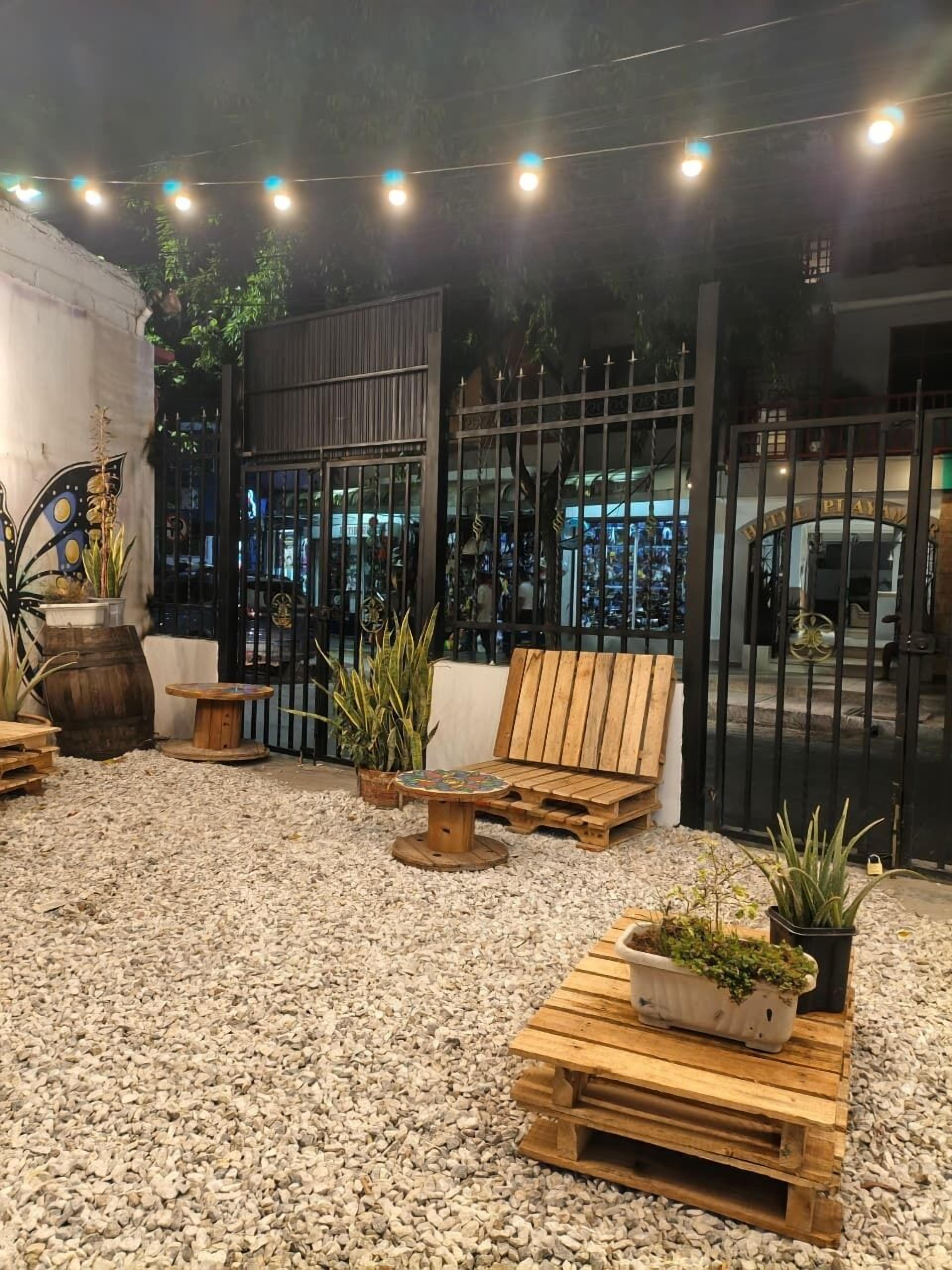 A patio area with outdoor seating, a decorative butterfly sculpture, and a gated entrance.