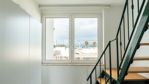 A staircase with wooden steps and green metal railings leading to a white door with a window. - Kaleido Sea View by BarbarHouse (Polignano a Mare)