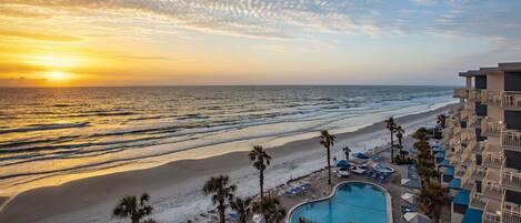 A resort with a pool, beach, and ocean view.