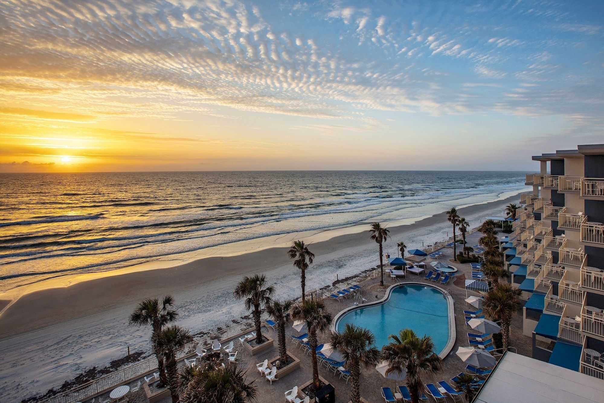 A resort with a pool, beach, and ocean view.