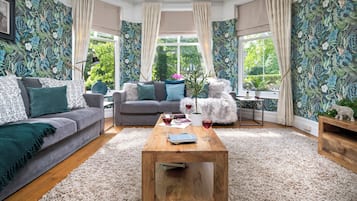 Un salon avec deux canapés, une table basse et une petite table d’appoint.