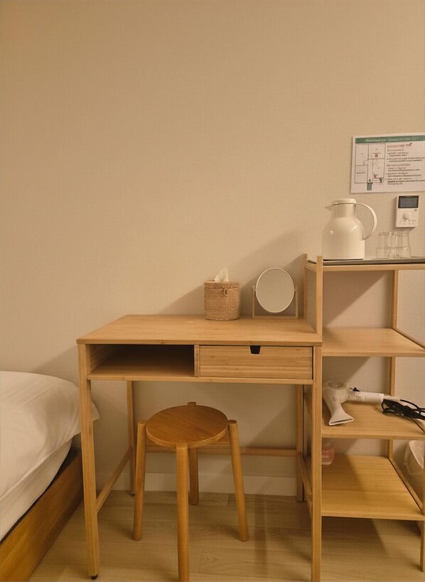 A wooden desk with a chair, a small shelf, a tissue box, a kettle, and a power outlet. - SoSi Stay (Seoul)