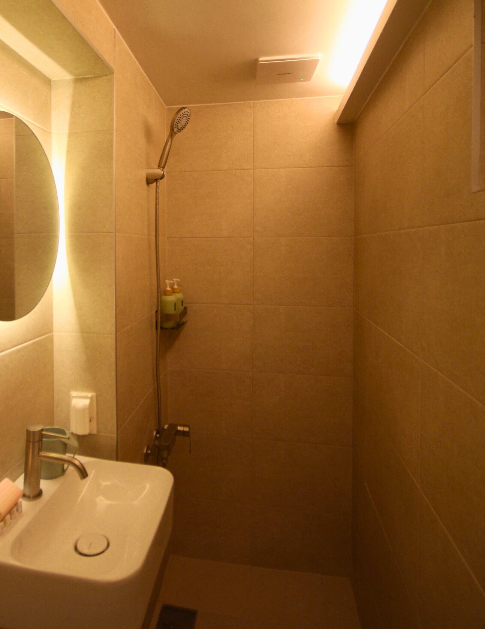 A bathroom with a sink, mirror, and shower.