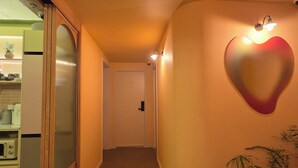 A hallway with a heart-shaped light fixture, a door, and a plant. - SoSi Stay (Seoul)