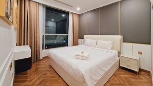Una habitación de hotel moderna con una cama grande, una mesita de noche, un armario y una ventana con cortinas.