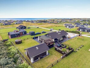 A residential area with houses, a large open space, and a view of the sea. - 4 Star Holiday Home in Lokken (Lokken)