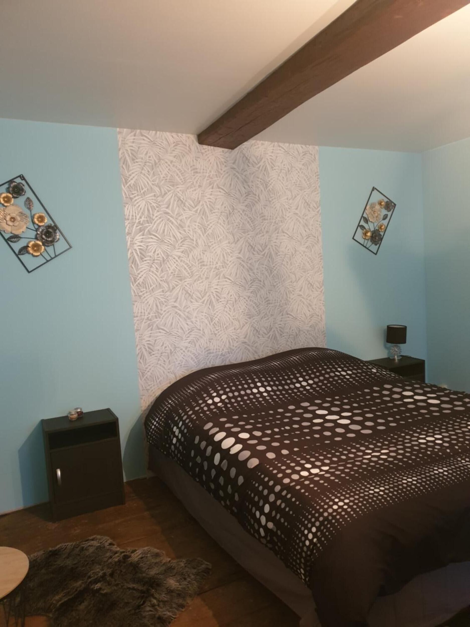 Une chambre à coucher avec un lit, une table de chevet, une lampe et un tapis.
