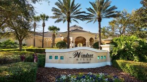 Segnaletica per il Windsor Hills Clubhouse, circondato da palme e verde curato.