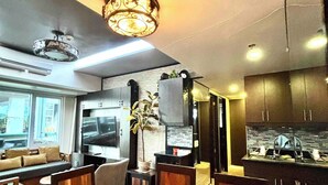 Una cocina moderna con armarios oscuros, horno empotrado y un amplio ventanal.
