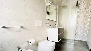 Ein Badezimmer mit einer Bidet, Toilette und einem Waschbecken.
