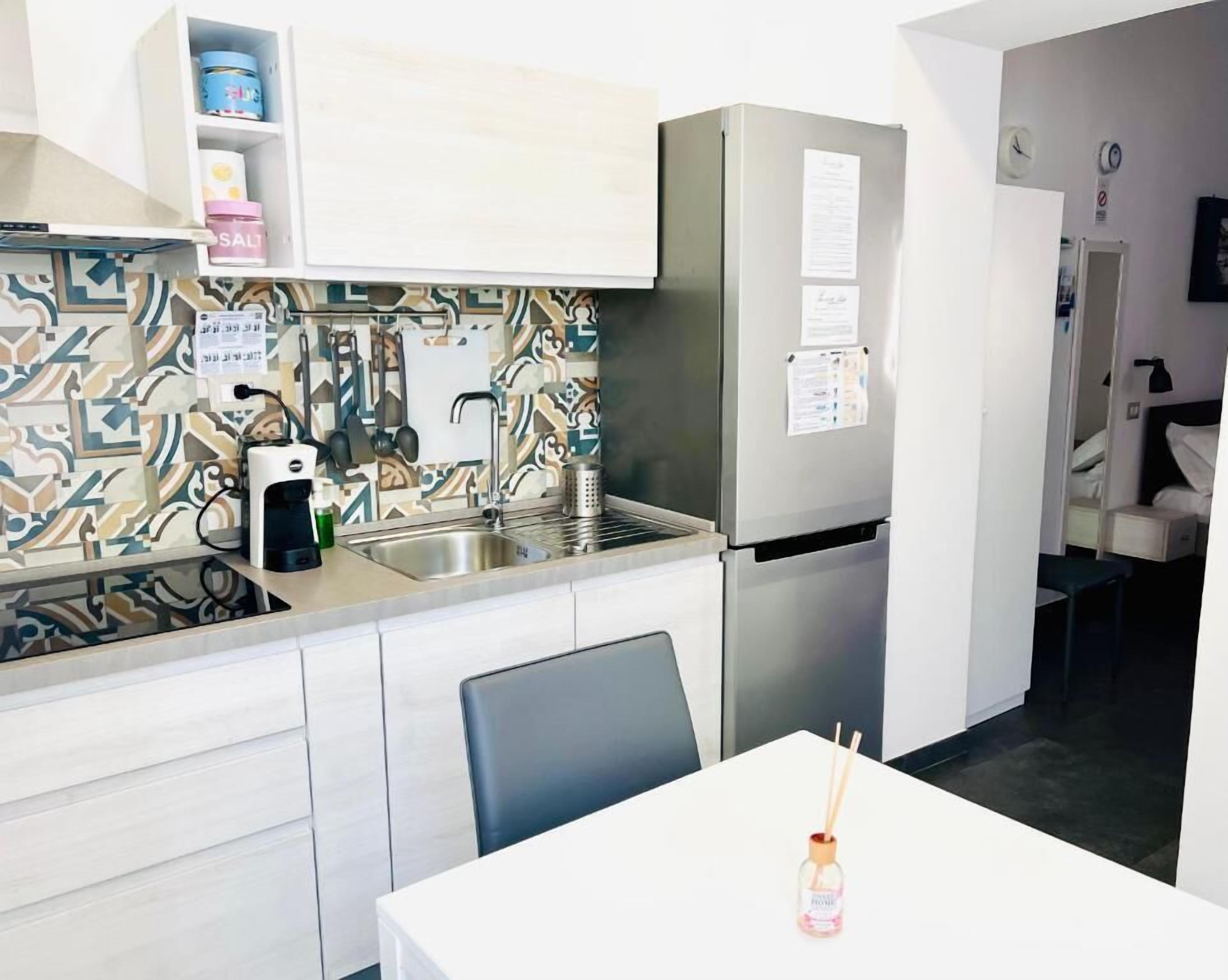 A compact kitchen with a refrigerator, sink, and a small dining area.